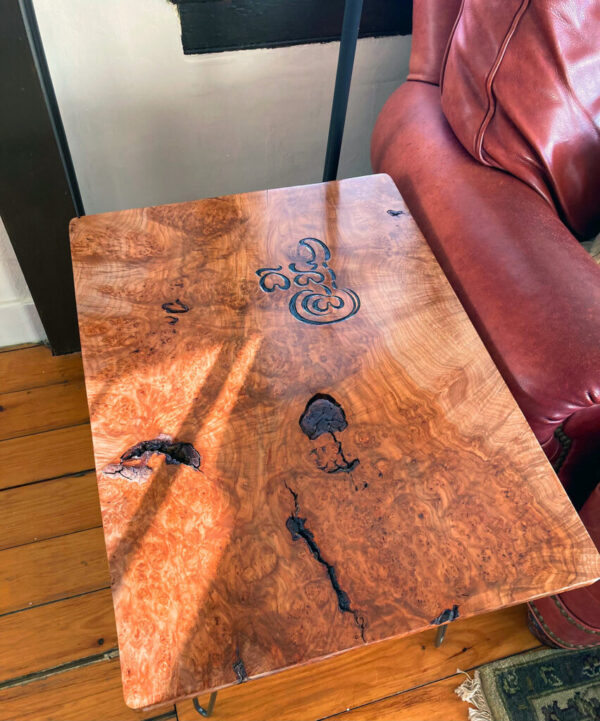 Side table made of bigleaf maple burl, into which is carved the word “Dharma” in the graceful but extinct Pallava script